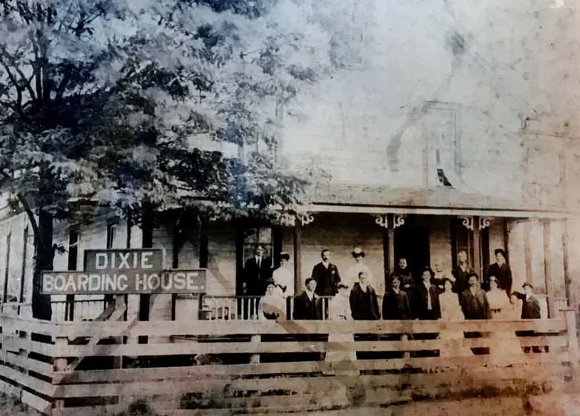 Boarders lined along the porch rail of the Dixie Boarding House