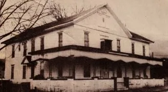 The white two-story H and H Rooming House